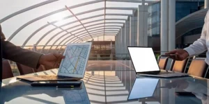 Two investors review how car wash syndication works on their laptops.