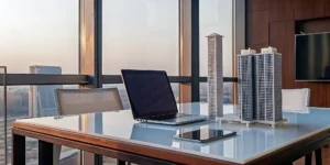 An accredited investor's desk with models of top real estate syndication platform deals.